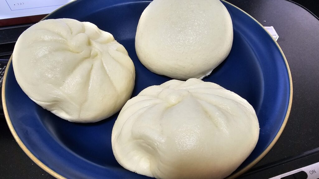 蒸した中華まん3個を青い皿に盛り付けた様子
