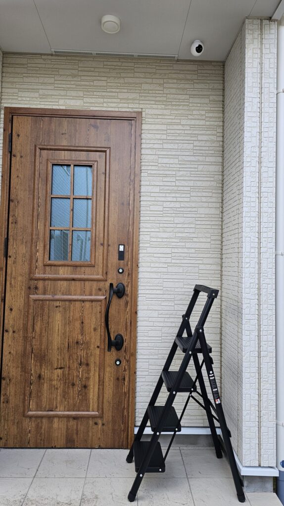 防犯カメラの下に脚立をセッティングして調整の準備をした様子。